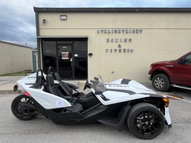 Slingshot parked in front of building.