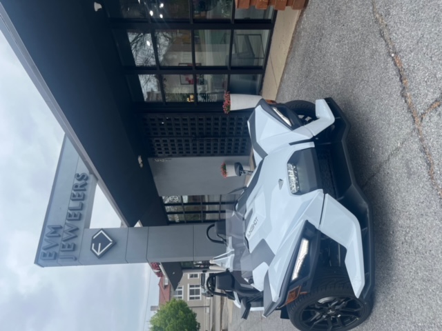 Frontal view of Slingshot parked in front of building.